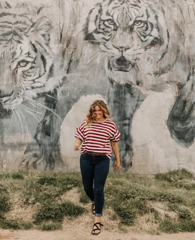 Dziewczyna stojąca przy ścianie z namalowanym tygrysem